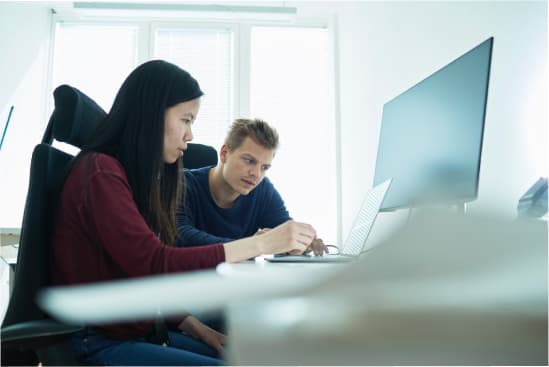 Two people working on a computer together